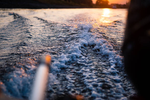 水に沈む夕日に向かって振り返る - クリンカーディンギー ストックフォトと画像