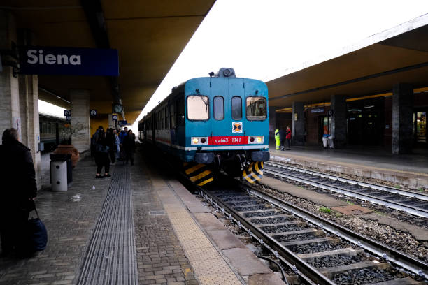 Contemporary suburban train on rails and empty platform of roailroad station in Alba, Italy.