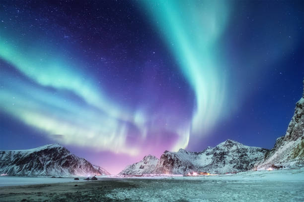 ノルウェーのロフォーテン諸島のオーロラボレアリス。山の上の緑の北のライト。オーロラと夜の冬の風景。ノルウェーの自然背景 - 北極光 ストックフォトと画像