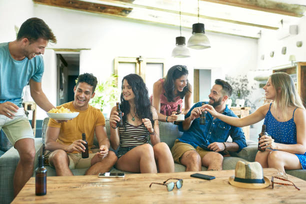 istock Socializing Young Friends on Sofa with Potato Chips and Beer 1185459682