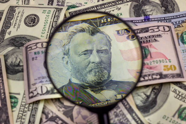 50米ドル紙幣が虫眼鏡の下で点検された。金融コンセプト、お金の背景 - imitation currency white collar crime discovery ストックフォトと画像
