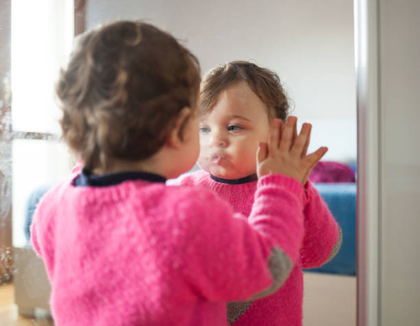 istock Cute Girl Puckering Lips While Looking At Mirror In Bedroom 1185459889