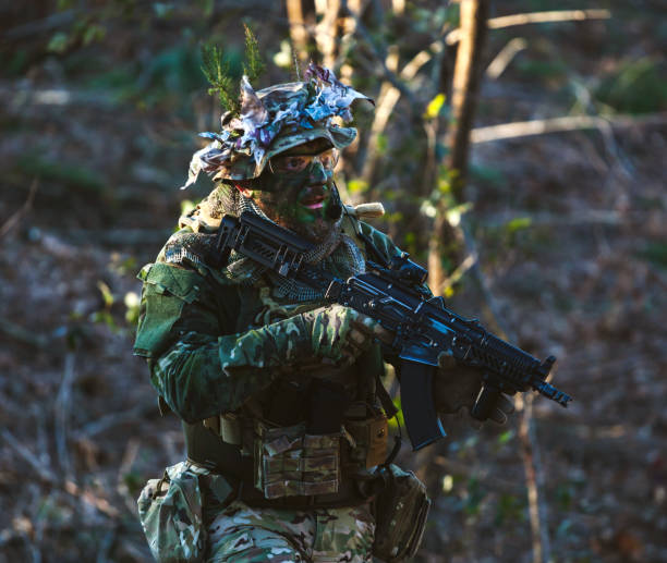 istock Soldier Holding Gun At Forest 1185460114