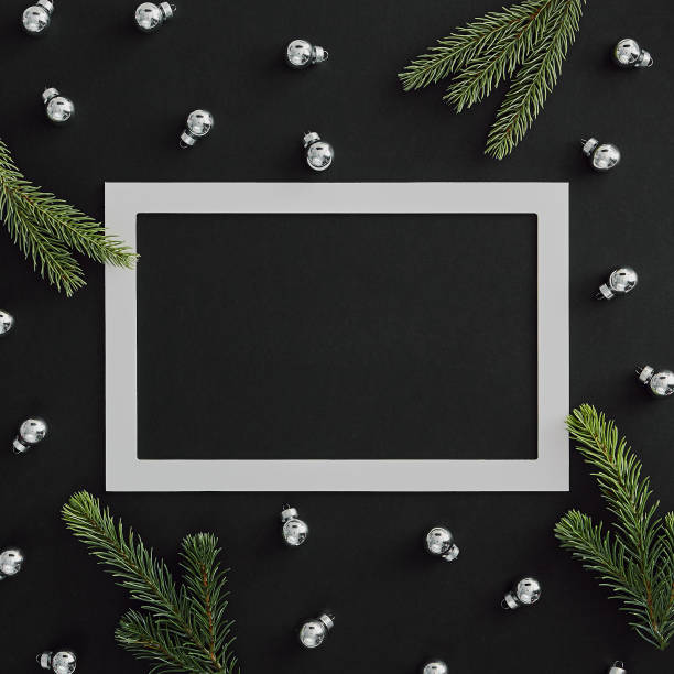 istock Silver bauble and evergreen tree branch on dark background 1185463780