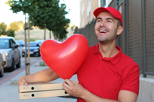Italian pizza delivery guy holding heart balloon.