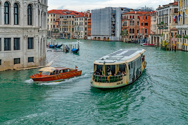 Venice, Italy - Oct, 2019: View from the Rialto Bridge of the Grand Canal in Venice. This is taken from a public access point on the bridge looking at the water taxis, waterbus and gondolas on the canal on a rainy day.