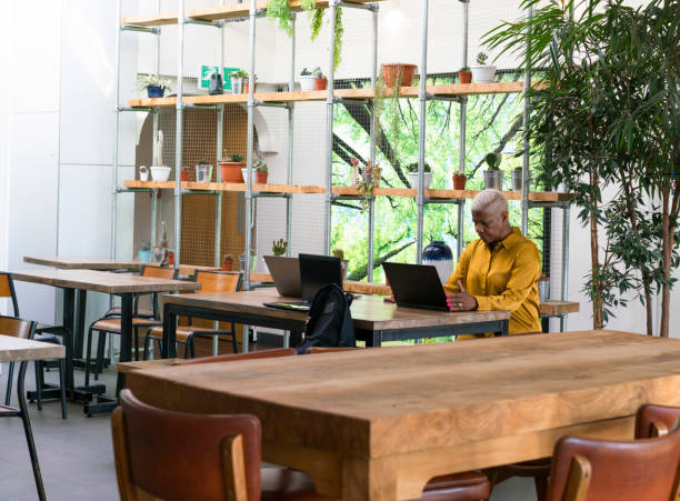 istock senior woman working in shared office space cafe. 1185465614