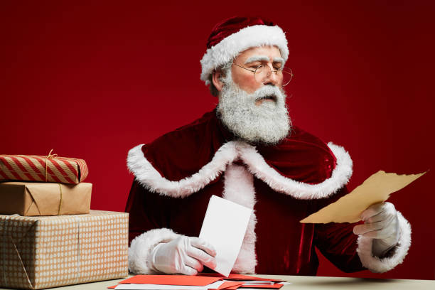 istock Santa Claus Reading Letters on Red 1185465680
