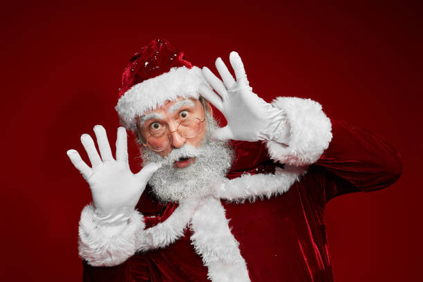 istock Santa Claus Making Faces against Red 1185465748