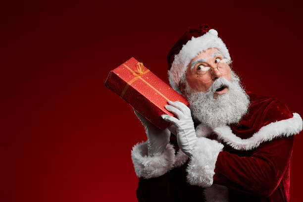 istock Santa Holding Christmas Present o Red 1185465861