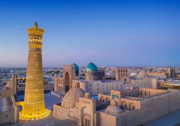 Panoramic view of the center of Bukhara around the Kalyan minaret (nearly 46 m hight and build in the early 12th century!). In the background of the minaret the Mir-i Arab Madressa and the Kaylan mosque (both 16th century) are visible. The center of Bukhara (also calloed Buchara or Buxoro) is listed as UNESCO World Heritage Site. Bukhara was one of the most important oasis and place of caravanserais at the Great Silk Road.