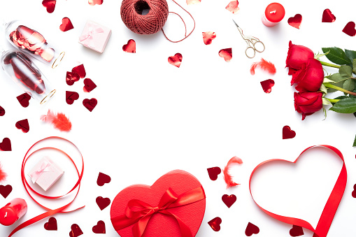 Valentine day composition with red gift box, bow and small hearts on white background. Top view.