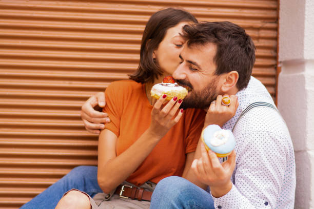 istock Couple eating donuts on street. 1185467441