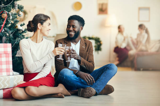 istock Mixed-Race Couple by Christmas Tree 1185468240