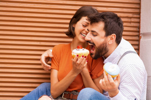 istock Couple eating donuts on street. 1185468269