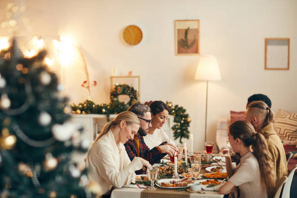 people enjoying christmas dinner in elegant interior - dinner friends christmas imagens e fotografias de stock