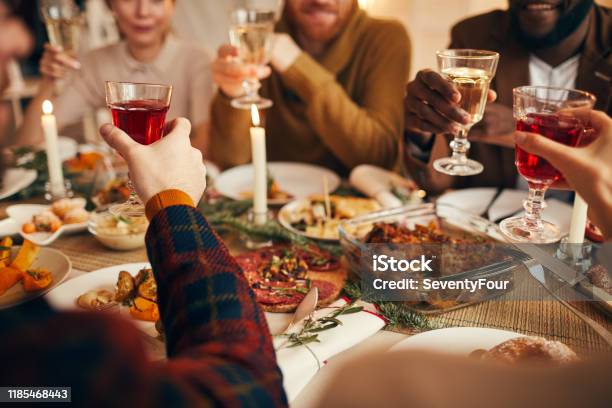 Raising Glasses At Dinner Party Close Up Stock Photo - Download Image Now - Christmas, Dinner, Food