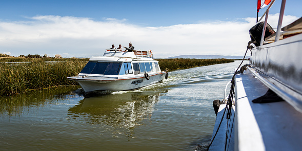 Puno, Peru - Circa 2014: Boats with people on Titicaca lake circa 2014 in Puno region, Peru