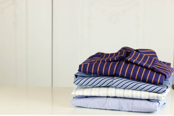 istock pile of ironing shirts and hand 1185469039