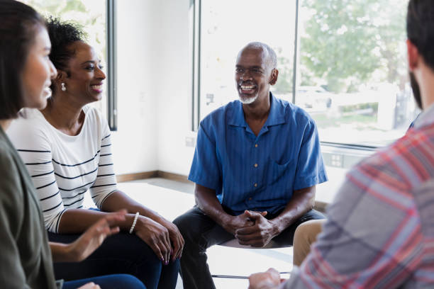istock Cheerful man shares during support group meeting 1185469300