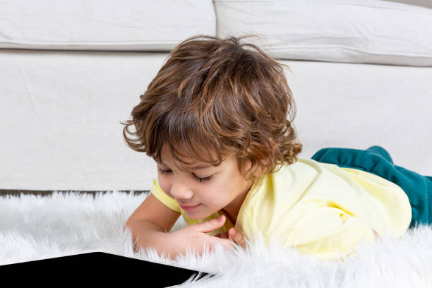 istock Little Boy working tablet on carpet 1185469389