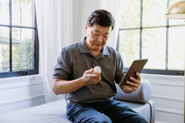 istock Senior man compares his prescription with the internet information 1185469674