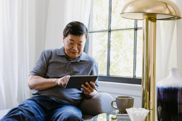 istock The senior man enjoys e-reader and cup of tea 1185470043