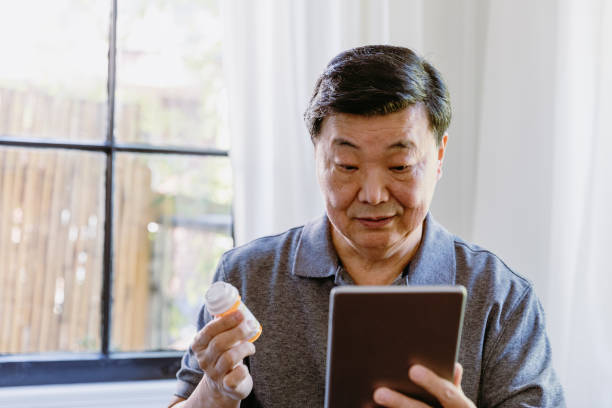 Senior man reads information on tablet about his medication