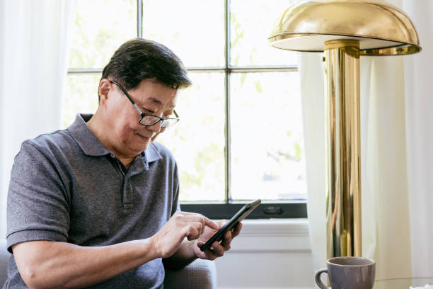istock Senior man uses his glasses to clearly see tablet screen 1185470048