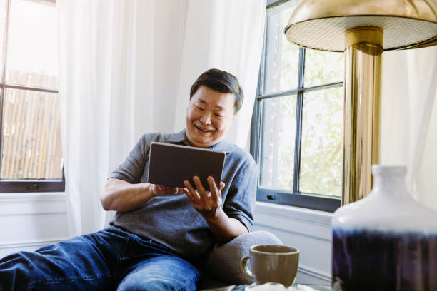 istock Man enjoys cup of coffee and good book on e-reader 1185470051