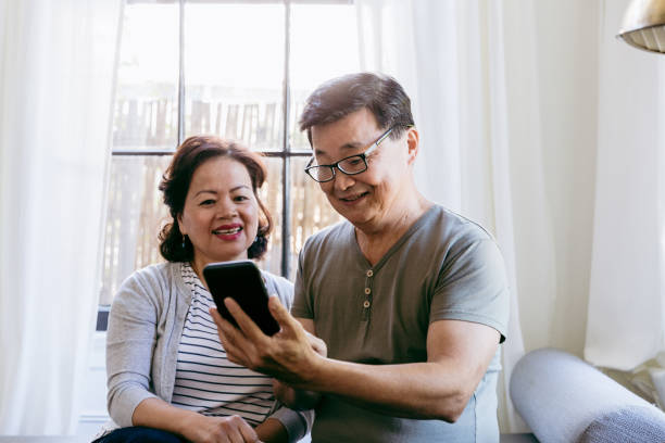 istock Senior couple enjoys looking at photos on digital tablet 1185470076