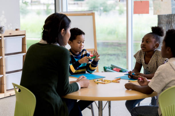 istock Art teacher assists group of students 1185470220