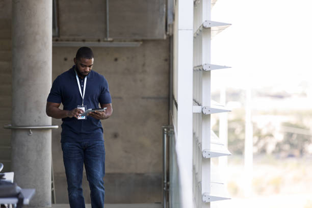 istock Mid adult business man walks on balcony while texting 1185470245
