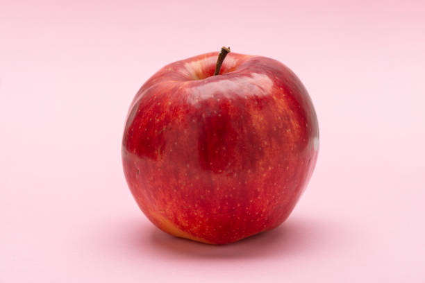 mela rossa, su sfondo rosa, jonagold - jona gold foto e immagini stock