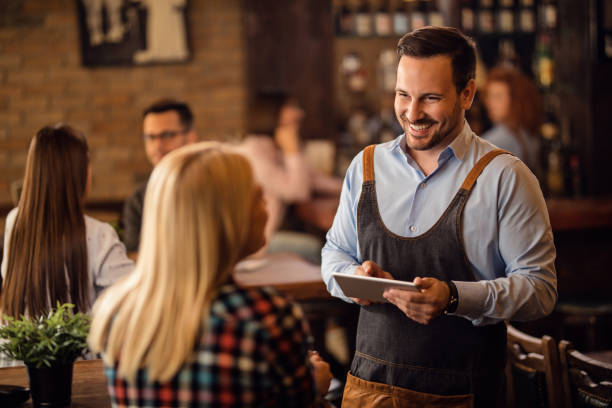 empregado de mesa feliz com touchpad que toma uma ordem de um convidado em um pub. - waiter - fotografias e filmes do acervo