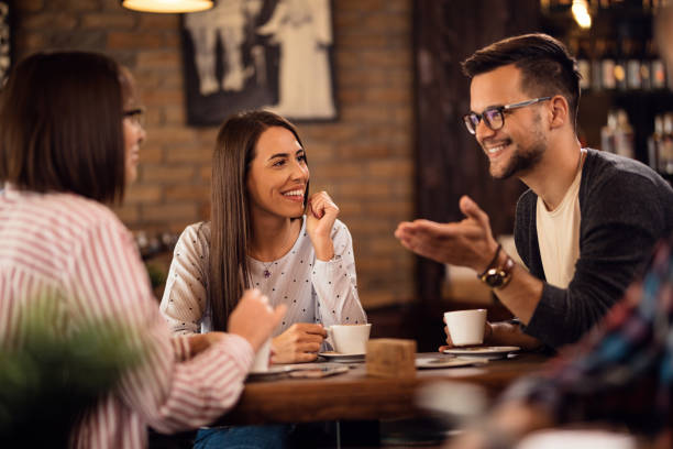 istock Happy friends having fun while drinking coffee and communicating in a cafe. 1185472991