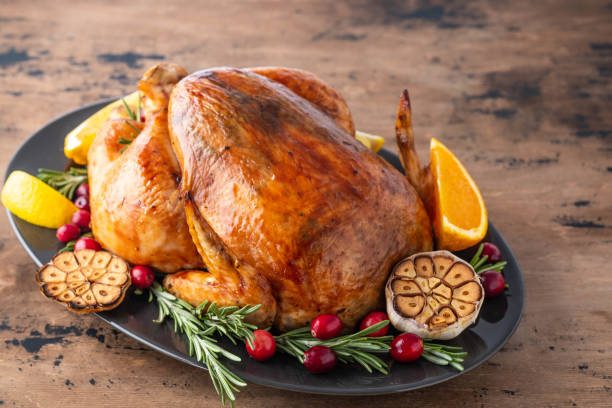 Christmas chicken with thyme and cranberries on a wooden table. Christmas atmosphere. Thanksgiving dinner, Thanksgiving turkey. Served table. Thanksgiving table served with turkey, decorated with bright autumn leaves. Roasted turkey, table setting sauces table turkey christmas stock pictures, royalty-free photos & images