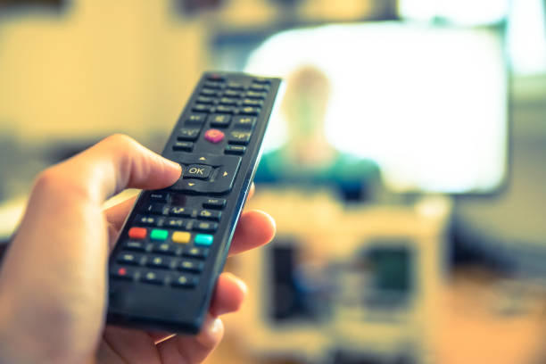 istock Male hand is holding TV remote control, smart TV. 1185475504