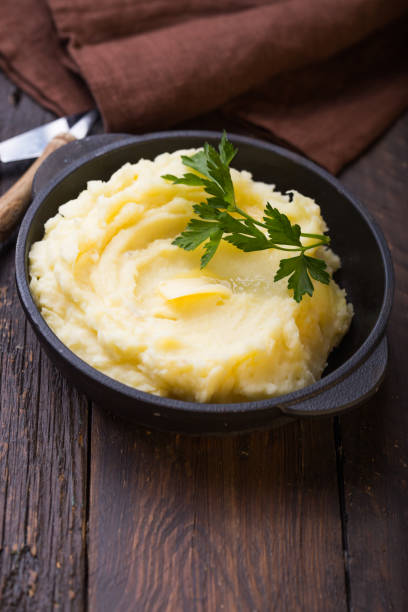 istock Mashed potatoes or boiled puree with parsley  in cast iron pot on dark wooden rustic background.  top view 1185475810