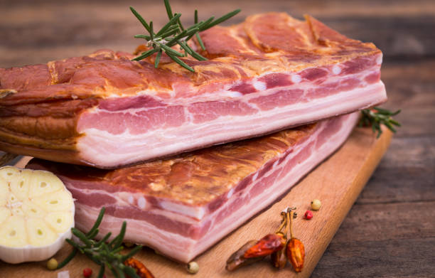 hausgemachter geräucherter speck auf holzbrett - raw bacon stock-fotos und bilder