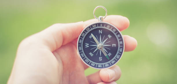 istock Innovation concept: Man is holding a compass in his hand, closeup cutout 1185475821