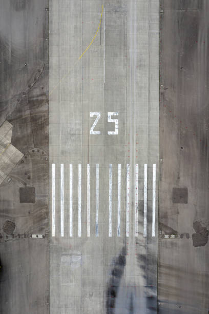 Directly above view of an airport runway with the direction marking 25 (250 degrees), and the runway threshold markings.