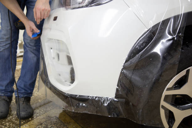 istock Installation of protective film for car paint. 1185478644