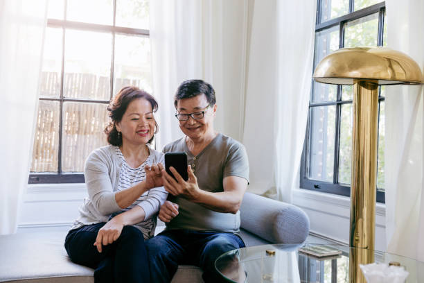 istock Senior wife points to photo on digital tablet husband holds 1185478775