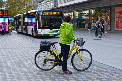 Ljubljana, Slovenia - October 4, 2019: Cyclist looks at city bus.