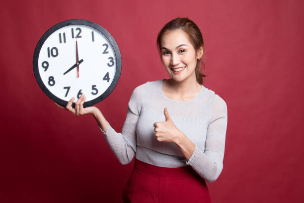 istock Young Asian woman thumbs up with a clock. 1185478969