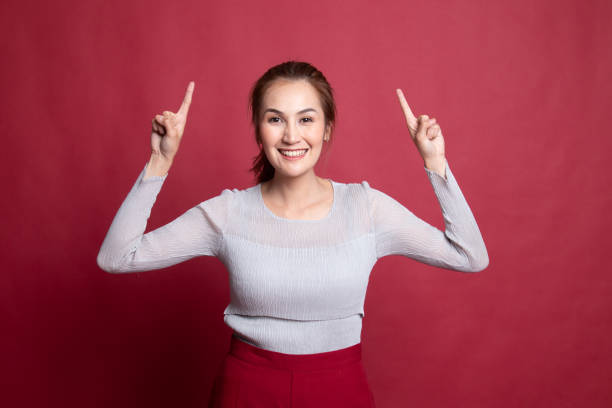 istock Young Asian woman point to blank space. 1185485461