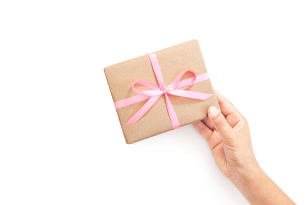 istock Female hands holding present box or gift box package in craft paper 1185485778