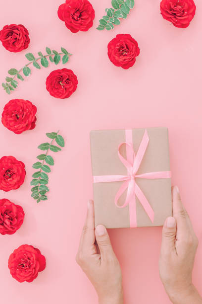 istock Female hands holding present box or gift box package in craft paper 1185486022