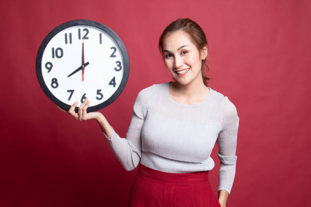 istock Young Asian woman with a clock. 1185488330
